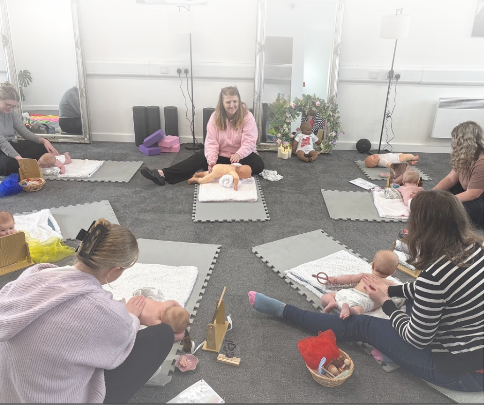 Image of baby massage class in progress at Tiny Hands Baby Massage, showing mums and babies and class teacher learning strokes, sensory baskets and massage oil